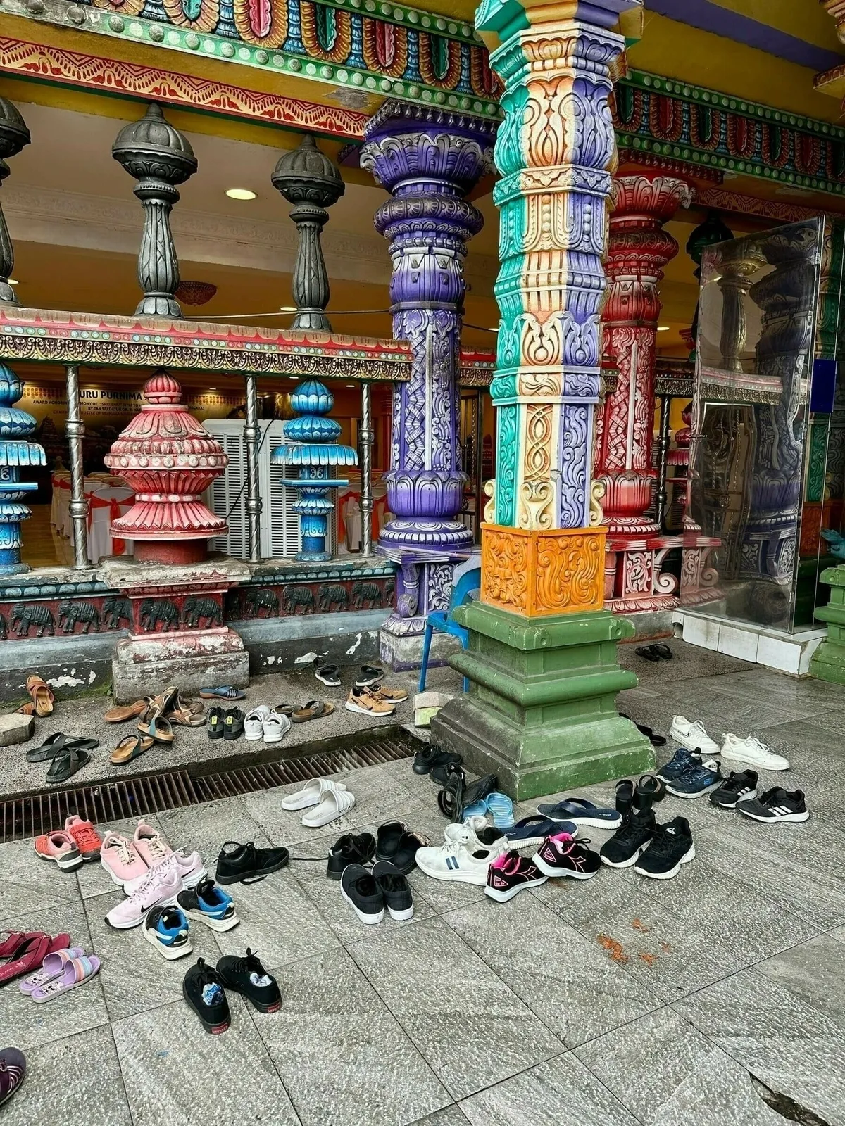Innenraum der Batu Caves mit hohen Felswänden und Tempelanlage.