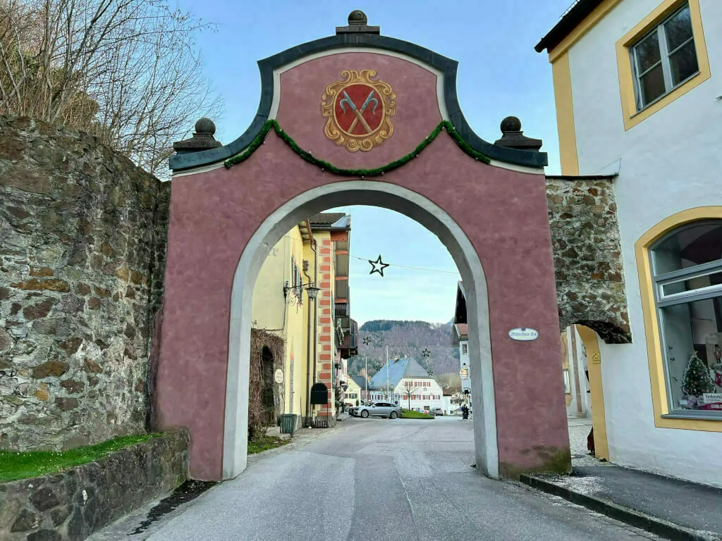 Das historische Münchner Tor in Neubeuern mit Wappen und Durchblick in den Ortskern.